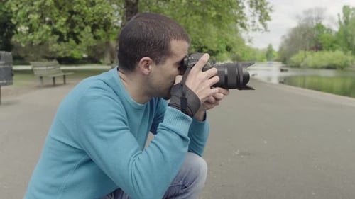 Photographer Taking Photos by a Pond in a Park. On