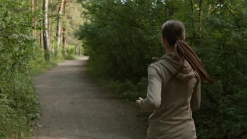 Unrecognizable Woman Jogging in Forest