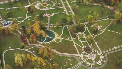 Uma vista aérea mostra um parque com caminhos sinuosos e recursos aquáticos que misturam arte e natureza na Bielorrússia