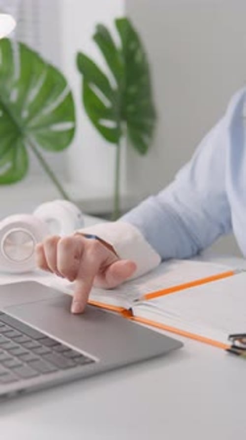 In This Vertical Video a Young Female Blogger Works on Her Laptop in Her Cozy Home Office She