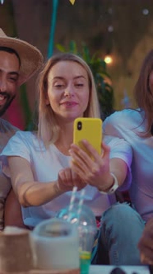 Friends Laughing at Phone Together Outdoors