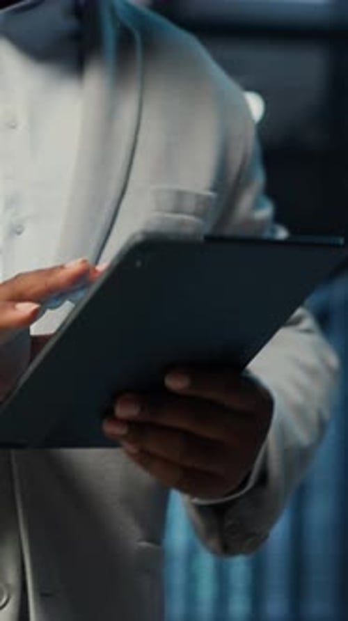 Vertical Video Data Center System Administrator Coding on Tablet Doing Software Updates