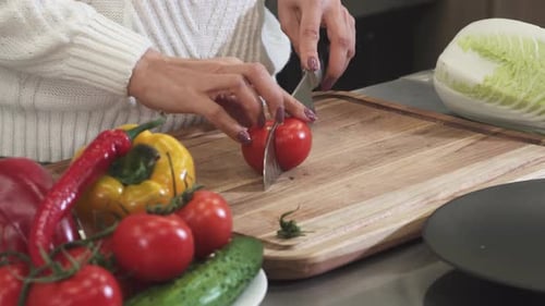 Woman Slicing a Tomato for Salad Preparation