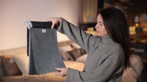 Joyful Woman on the Infurniture Store Decides What Fabric to Choose for Furniture