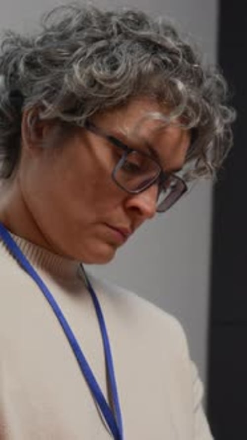 Female Therapist Taking Notes Overseeing Support Group in Prison Vertical