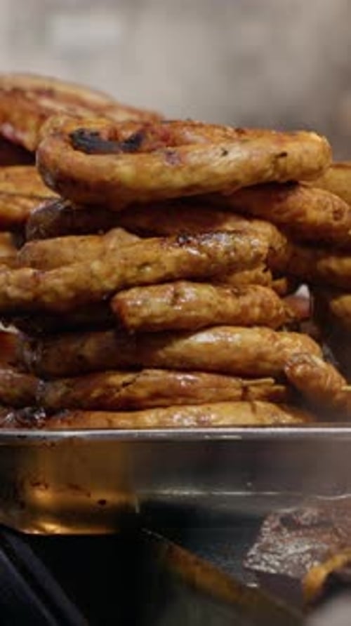 Vertical video Street food vendor preparing sausages