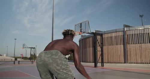 Shirtless Black Athlete Throwing Ball Into Ring