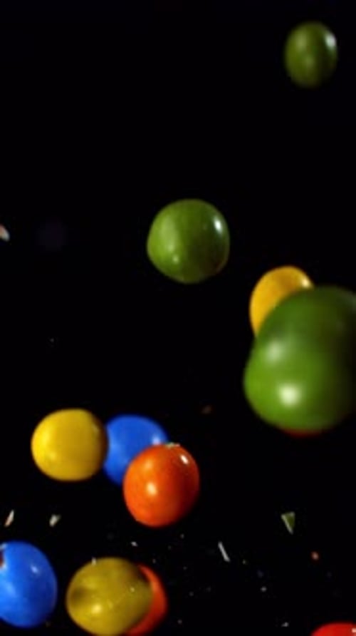 Colorful Candies Floating in Slow Motion on Black