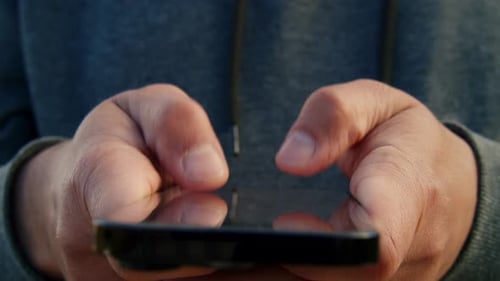 Millennial Man Using Smartphone At Sunset On City Street Cinematic Shot