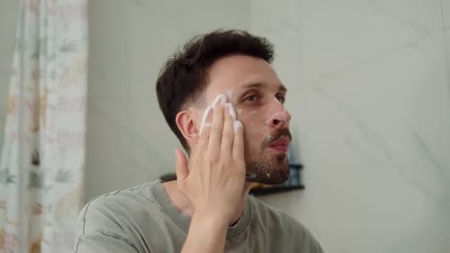 Man Cleansing Face with Foamy Skincare Product