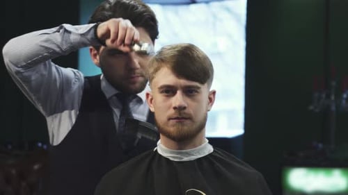 Handsome Young Man Enjoying a Stylish Haircut at the Barbershop