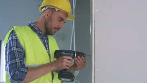 Construction Worker Drilling in Indoor Space