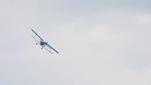One blue old propeller bi plane flying sky airshow. Biplane flight fly air show.