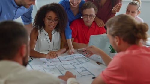 Focused business team discussing design project at table in modern office
