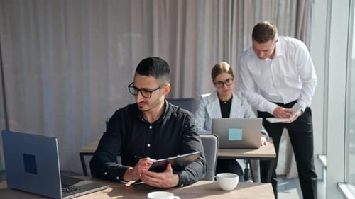 Collaborative Office Work with Colleagues Using Laptops