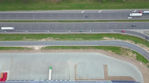 Logistics park with warehouse, loading hub and many semi trucks with cargo trailers standing at the