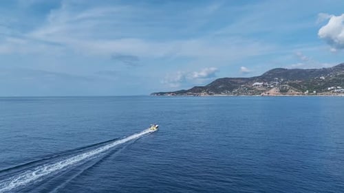 Aerial Video of a HighSpeed Motorboat Approaching the Marina Leaving a White Trail on the Deep Blue