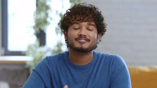 Friendly Young Man Waving and Smiling to Camera