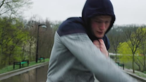 Athletic Young Man Shadow Boxing in Park