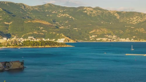 Vista desde arriba del complejo turístico de Budva con hoteles y playas y barcos con barcos que navegan de costa a costa