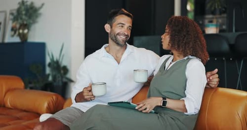 Couple on Couch Drinking Coffee and Talking