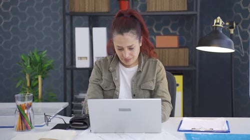 Woman Working at Laptop in Office Environment