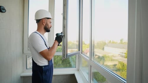Worker Installing Window with Power Drill for a Secure Fit