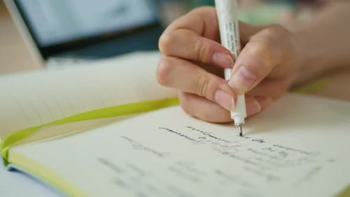 Hand Writes in Notebook with Pen Close Up