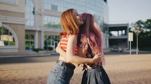Two Young Women Meet in the Park Girlfriends Met in the Park The Girls are Happy to See Each Other