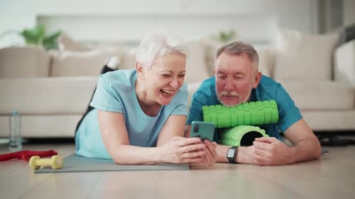 Senior Couple Relaxing after Exercise with Smartphone