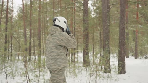Snowy Pine Forest Scene with ATV Inspection and Gear Check Outdoor Rider Inspects Red ATV in Winter