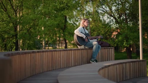Leisurely Guitarist During Sunset on Quiet Park Bench Chilled Acoustic Player in Denim Attire