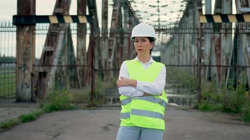 Professional Engineer Woman Manager Standing with Crossing Hands Wearing Helmet on Metal