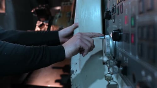 Arbeiter verwendet das Bedienfeld der Drehmaschine in der CNC-Fabrik