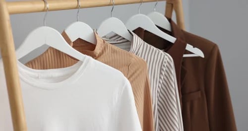 Stylish shirts and jacket hanging in closet