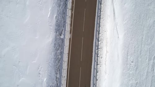 Aerial Top Down View on a Road Between the White Snowy Fields Beautiful Winter Landscape