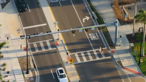 Crowded City Street in Sarasota with People Walking Across Marked Crosswalk While Cars Wait at