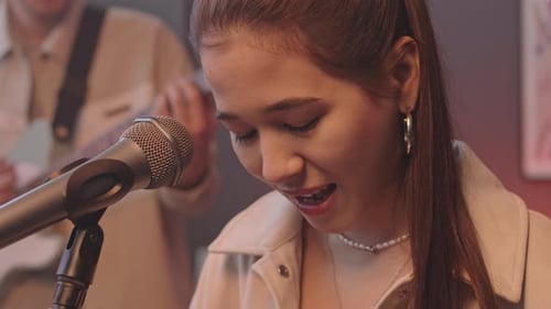 Woman Sings and Plays Keyboard in Music Studio
