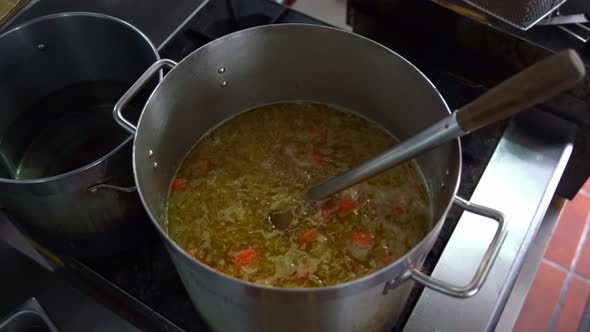 Chef adding blocks of Japanese curry roux into a big stock pot on ...