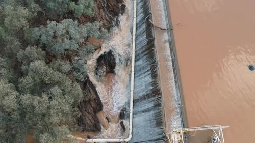 Flood waters cascading over a dam wall from a drone 10