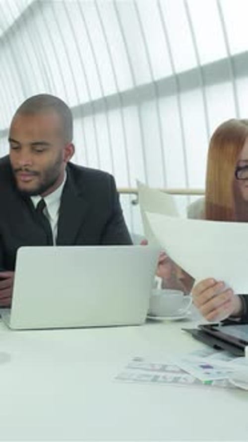 Colleagues Working Together at Desk in Office