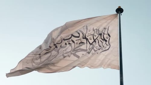 Flag Waving in the Wind Against Clear Sky