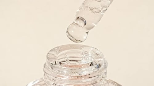 Liquid Dropping from Pipette into Glass Bottle