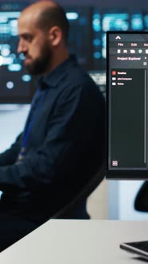 Man Coding at Computer in Dark Data Center