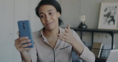 Woman Video Chats with Smartphone in Office