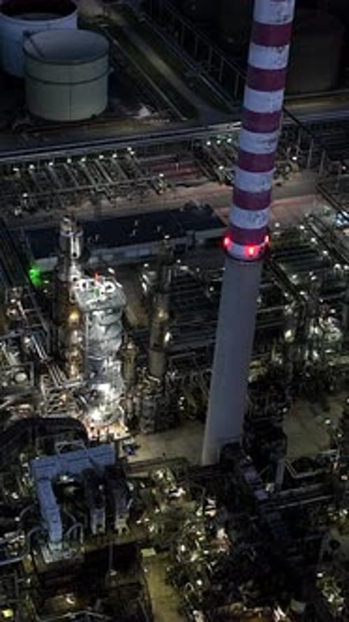 An Industrial Power Plant Lit at Night Highlighting Its Intricate Machinery and Operations