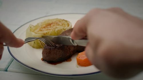 Eating Beef Steak with Fork and Knife POV
