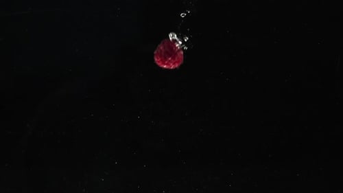 Fresh Raspberries Falling Into Water Against Black