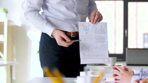 Business, Corporate and People Concept - Businessman Showing Papers with Charts To