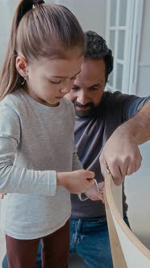 Adorable Little Daughter and Father Fixing Parts of New Chair